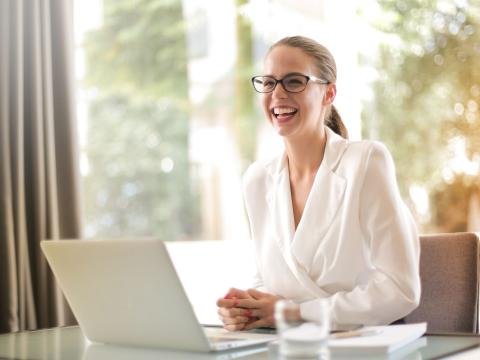A businesswoman smiling during a conversation at her laptop